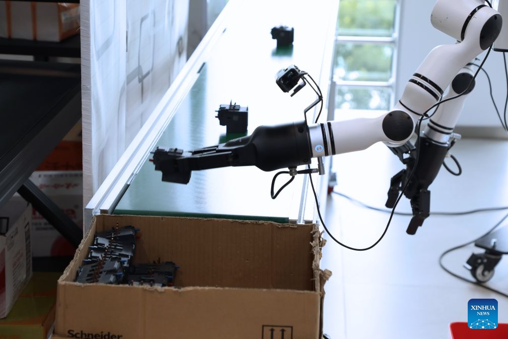 A robot is trained in a logistics scenario at a training center for embodied AI in Xiong'an, north China's Hebei Province, June 23, 2026. Xiong'an in Hebei Province has established a training center for embodied AI tailored to various scenarios since December 2025. Equipped with simulated workshops replicating real-world environments, massive amounts of robots' data are generated, making embodied AI increasingly smart and capable of service in all walks of life. (Photo: Xinhua)