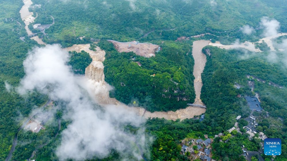 A drone photo taken on June 23, 2026 shows people visiting the Huangguoshu Waterfall in Anshun City, southwest China's Guizhou Province. Due to continuous rainfall and upstream inflow, Huangguoshu Waterfall in Anshun witnessed a surge in flow in recent days. (Photo: Xinhua)