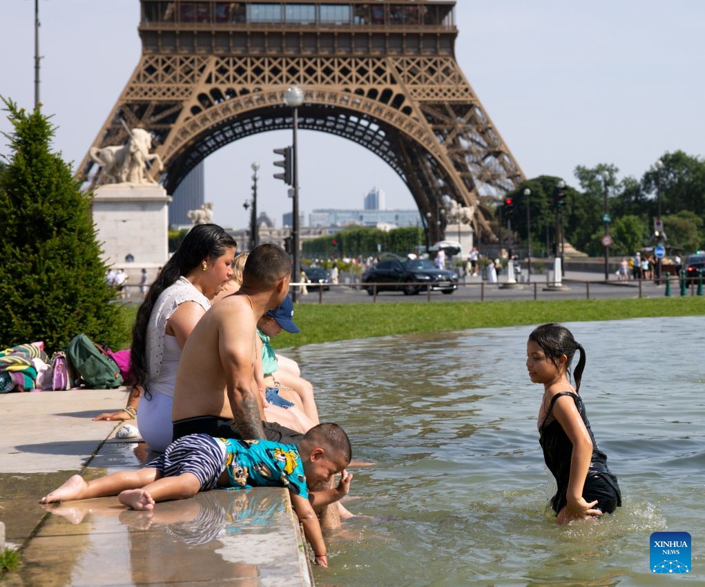 People cool off and relax at a fountain in front of the Eiffel Tower in Paris, France, June 23, 2026. The Eiffel Tower in Paris closed early on Tuesday due to high temperature. (Photo: Xinhua)