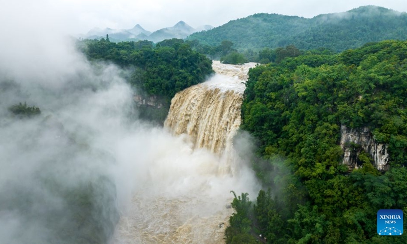 A drone photo taken on June 23, 2026 shows people visiting the Huangguoshu Waterfall in Anshun City, southwest China's Guizhou Province. Due to continuous rainfall and upstream inflow, Huangguoshu Waterfall in Anshun witnessed a surge in flow in recent days. (Photo: Xinhua)