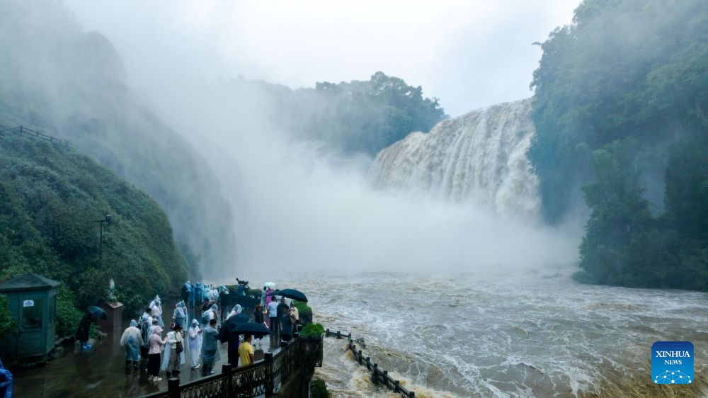 A drone photo taken on June 23, 2026 shows people visiting the Huangguoshu Waterfall in Anshun City, southwest China's Guizhou Province. Due to continuous rainfall and upstream inflow, Huangguoshu Waterfall in Anshun witnessed a surge in flow in recent days. (Photo: Xinhua)