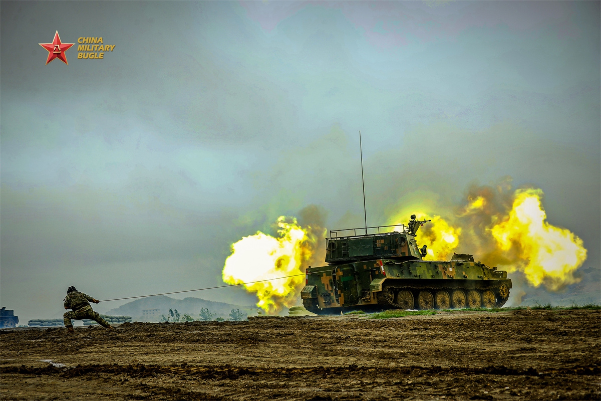 An artillery crew member assigned to an artillery unit of a brigade under the Chinese PLA Army uses a lanyard to fire the first round from a PLZ-89 self-propelled howitzer during a live-fire training exercise in early June, 2026. (Photo: eng.chinamil.com.cn)