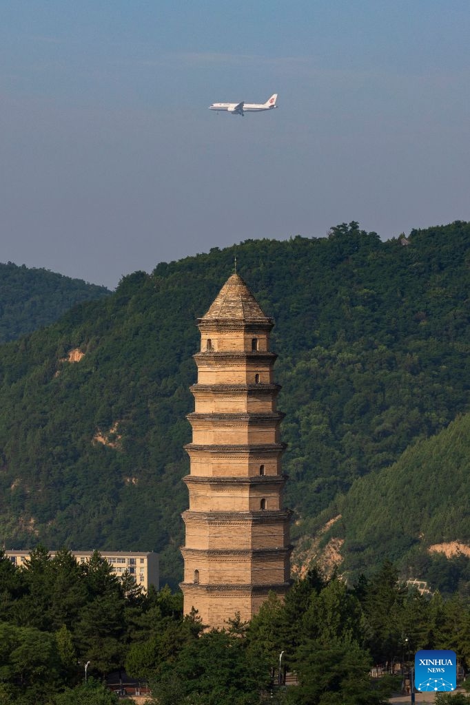 The flight CA1279 of Air China flies past the Baota Mountain in Yan'an, northwest China's Shaanxi Province, on June 24, 2026. Air China on Wednesday started using China's domestically-produced C919 jetliner on a new route linking Beijing with Yan'an of northwest China's Shaanxi Province. By far, Air China has opened a dozen of air routes from Beijing to old revolutionary base areas such as Jinggangshan, Zunyi and Yan'an, planning to offer 260 flights every week, to inject impetus into the development of these areas (Photo: Xinhua)