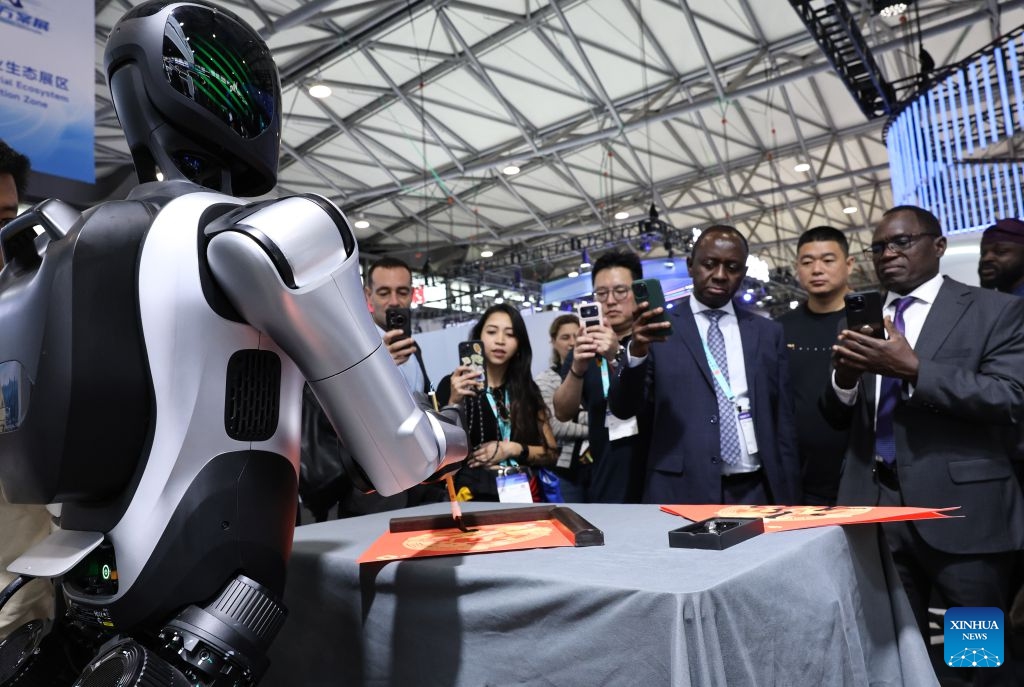 Visitors watch a robot writing calligraphy during the 2026 Mobile World Congress (MWC) Shanghai in Shanghai, east China, June 24, 2026. MWC Shanghai, slated for June 24 to 26 this year, is Asia's largest and most influential connectivity ecosystem event, with global leaders and innovators set share their visions for the future of connectivity at this showpiece in east China. (Photo: Xinhua)