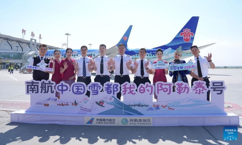 Crew members pose for a group photo in front of a painted plane at an airport in Altay, northwest China's Xinjiang Uygur Autonomous Region, June 24, 2026. China Southern Airlines held a launching ceremony for a painted plane on Wednesday, following which the plane will operate the flight from Altay to Beijing Daxing International Airport. (Photo: Xinhua)