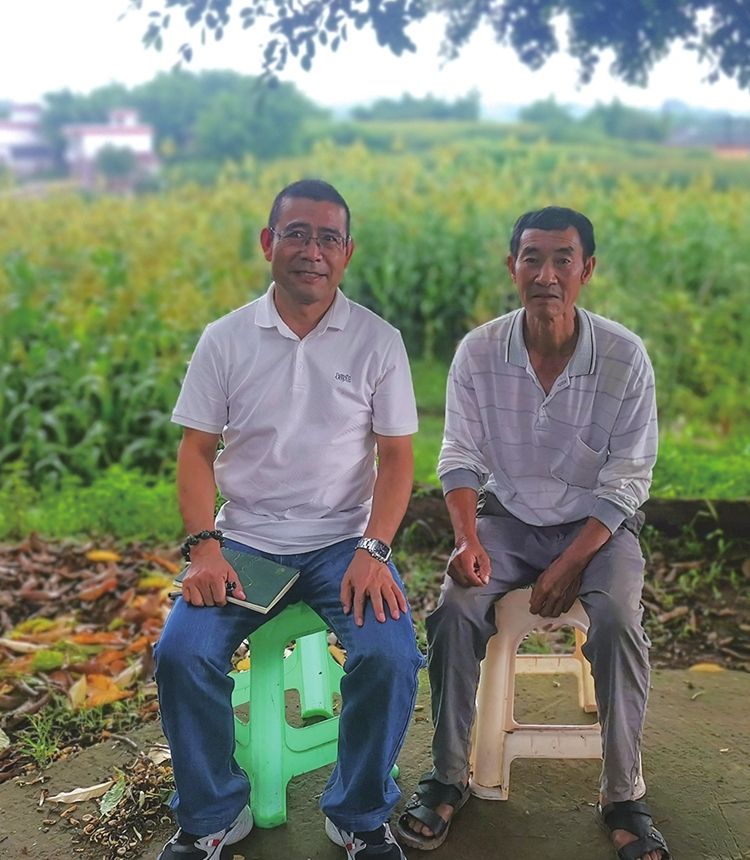 Writer Hu Xuewen sits with a villager. Photo: Courtesy of Hu Xuewen 
