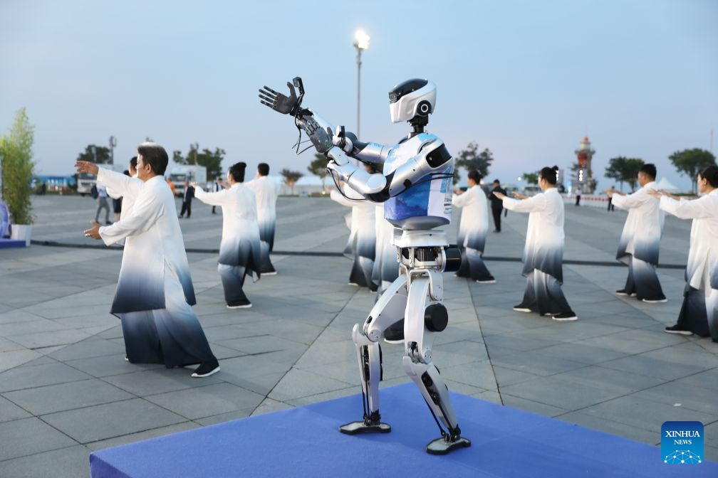 Performers and a robot perform at a cultural event held during the 17th Annual Meeting of the New Champions, also known as the Summer Davos, in Dalian, northeast China's Liaoning Province, June 24, 2026. At the event, attendees enjoyed cultural shows, tried a variety of local delicacies, and swapped ideas about possible partnership opportunities. (Photo: Xinhua)