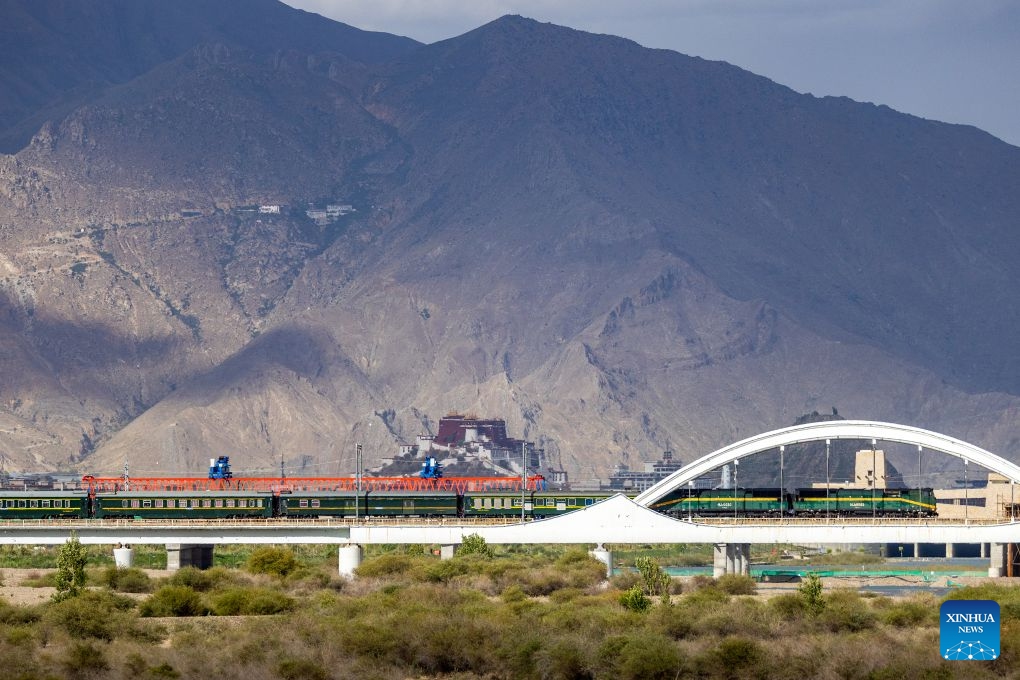 A train crossing a bridge over the Lhasa River on the Qinghai-Xizang Railway is pictured against the Potala Palace in Lhasa, southwest China's Xizang Autonomous Region, June 22, 2026. (Photo: Xinhua)
