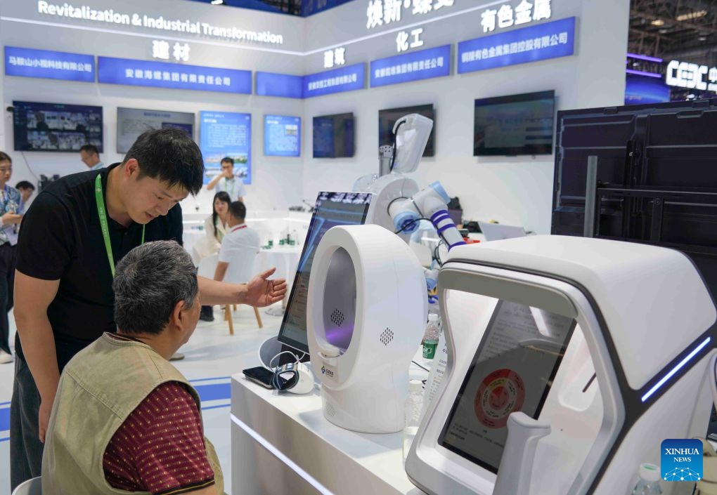 A staff member guides a visitor to experience an AI-assisted diagnostic system at the pavilion of China's Anhui Province at the exhibition area of Clean Energy during the Fourth China International Supply Chain Expo (CISCE) in Beijing, capital of China, June 24, 2026. Themed on Connecting the World for a Shared Future, the fourth CISCE is held in Beijing from June 22 to 26. (Photo: Xinhua)