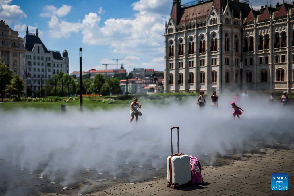 People cool off with a mist cooling system amid a heatwave in Budapest, Hungary, June 24, 2026. Hungarian authorities on Tuesday extended a nationwide second-degree heat alert until midnight on June 26 and announced that the warning level would be raised to a third-degree, the highest level, from June 27 through June 30 as extreme temperatures persist across the country. (Photo: Xinhua)