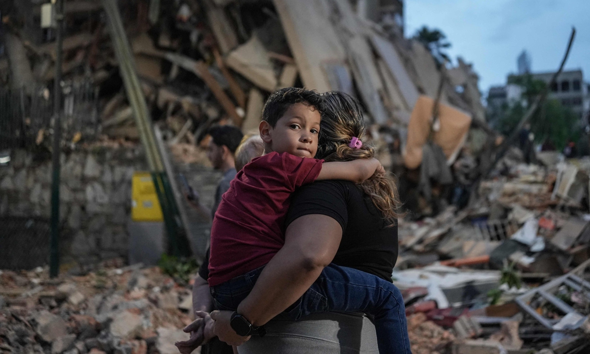 People walk past a collapsed building following earthquakes in Caracas, Venezuela, on June 25, 2026. Powerful twin earthquakes have killed at least 164 people and injured 971, the nation's acting president said Thursday. Photo: VCG