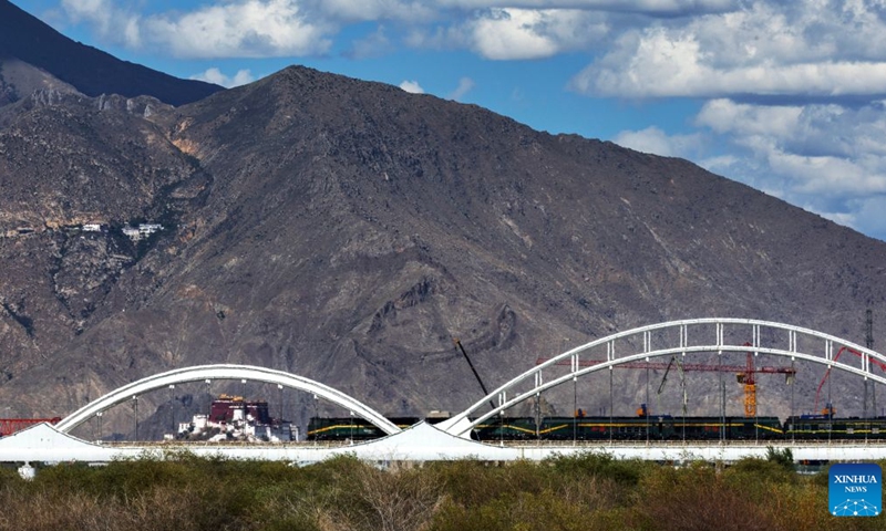 A train crossing a bridge over the Lhasa River on the Qinghai-Xizang Railway is pictured against the Potala Palace in Lhasa, southwest China's Xizang Autonomous Region, June 22, 2026. (Photo: Xinhua)