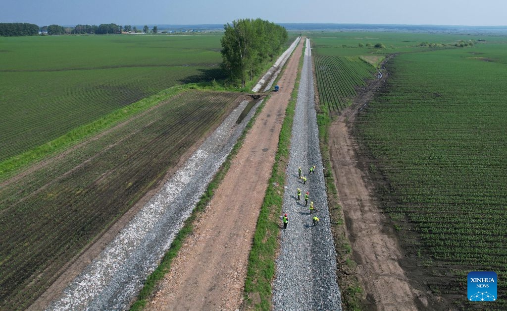A drone photo taken on June 24, 2026 shows workers working at a field of Beidahuang Group in northeast China's Heilongjiang Province. The province's 257.9 million mu (17.19 million hectares) of arable land features 156 million mu (10.4 million hectares) of black soil, representing 56.1 percent of the total black soil in northeast China. In 2025, the grain output in Heilongjiang reached about 82 million tonnes, ranking first nationwide for 16 consecutive years. (Photo: Xinhua)