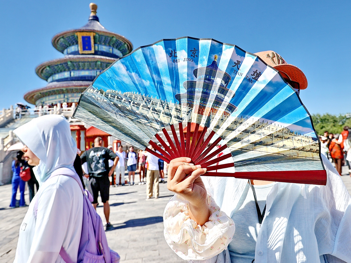 A tourist holds open a fan printed with the image of Tiantan (Temple of Heaven) during a visit to the famed landmark in Beijing on June 25, 2026. Tiantan Park was the most visited park in Beijing during the recent Dragon Boat Festival holidays. Photo: VCG 