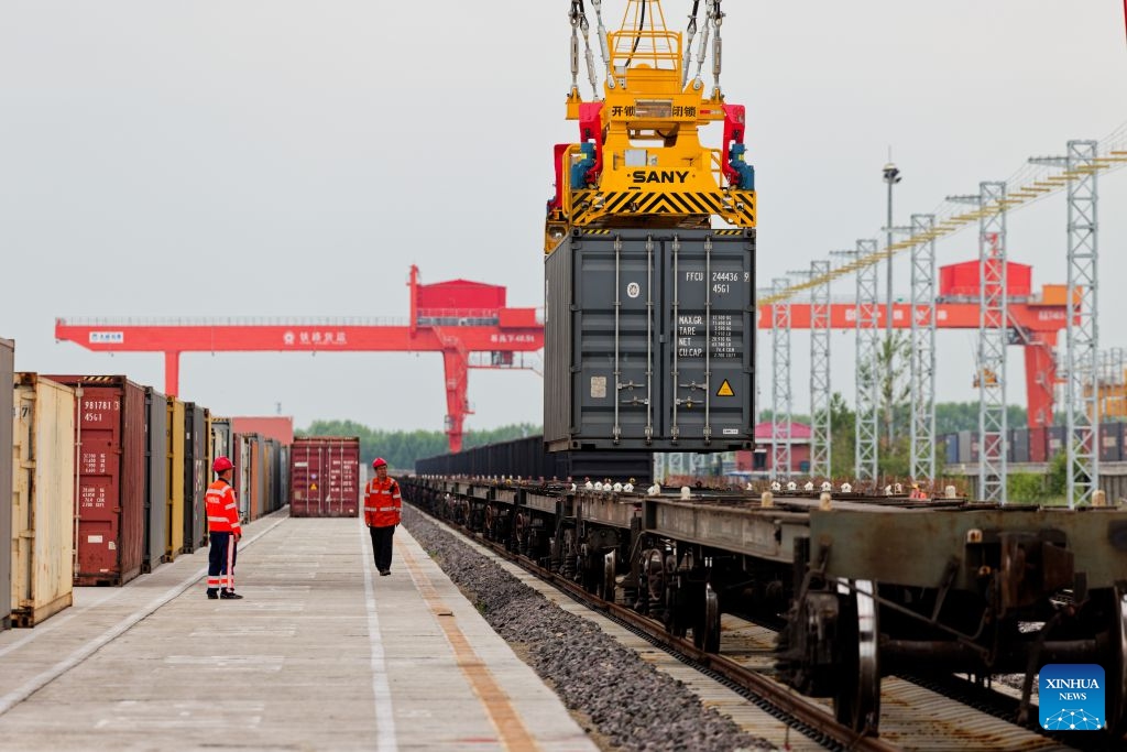 This photo taken on June 24, 2026 shows a crane lifting a container at a yard of transshipment operation of the Tongjiang North Railway Station in Tongjiang, northeast China's Heilongjiang Province. By June 23, Tongjiang railway port has handled 128 China-Europe freight train trips with 115,724 tonnes of goods, increasing by over 100 percent year on year. (Photo: Xinhua)