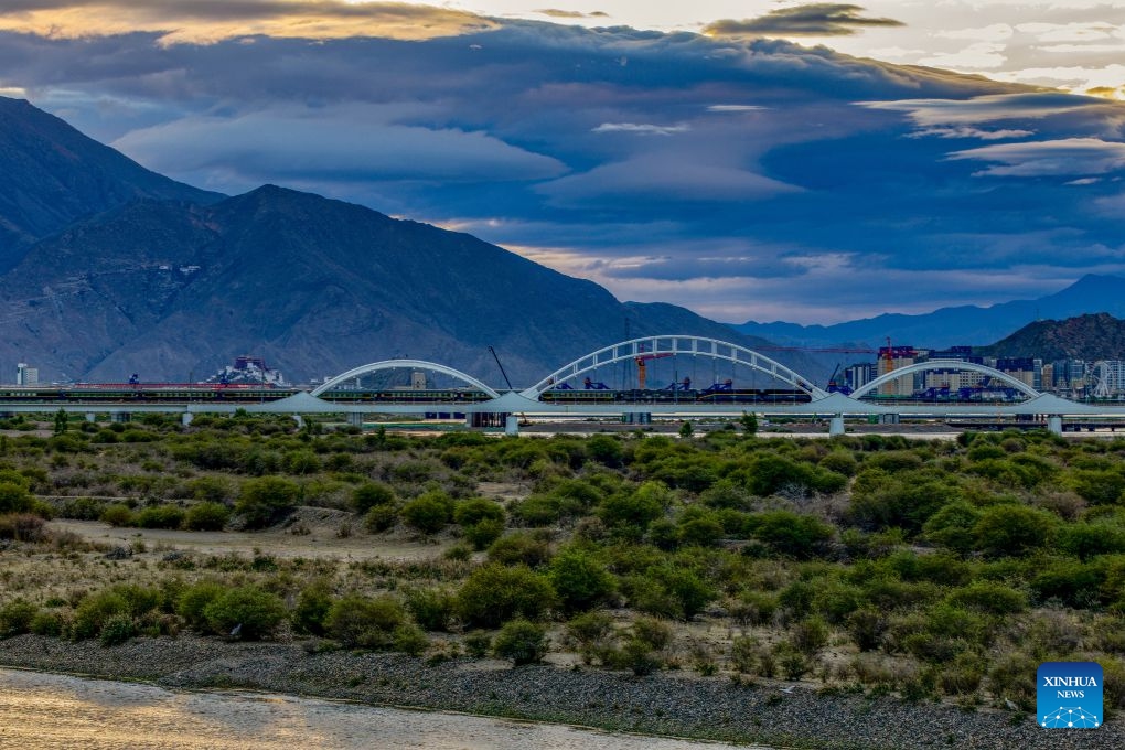 A train crossing a bridge over the Lhasa River on the Qinghai-Xizang Railway is pictured against the Potala Palace in Lhasa, southwest China's Xizang Autonomous Region, June 22, 2026. (Photo: Xinhua)