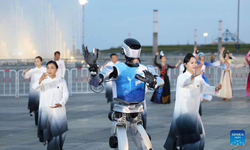 Performers and a robot perform at a cultural event held during the 17th Annual Meeting of the New Champions, also known as the Summer Davos, in Dalian, northeast China's Liaoning Province, June 24, 2026. At the event, attendees enjoyed cultural shows, tried a variety of local delicacies, and swapped ideas about possible partnership opportunities. (Photo: Xinhua)