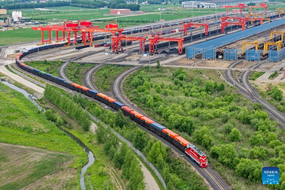 A drone photo taken on June 24, 2026 shows a China-Europe freight train arriving at a yard of transshipment operation of Tongjiang North Railway Station in Tongjiang, northeast China's Heilongjiang Province. By June 23, Tongjiang railway port has handled 128 China-Europe freight train trips with 115,724 tonnes of goods, increasing by over 100 percent year on year. (Photo: Xinhua)