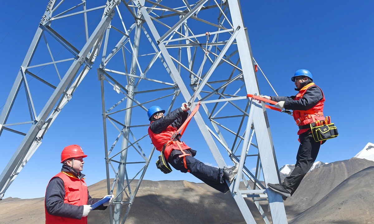 Workers from Anhui Province carry out power supply maintenance at an altitude of 5,548 meters in Shannan, Xizang. Photo: VCG