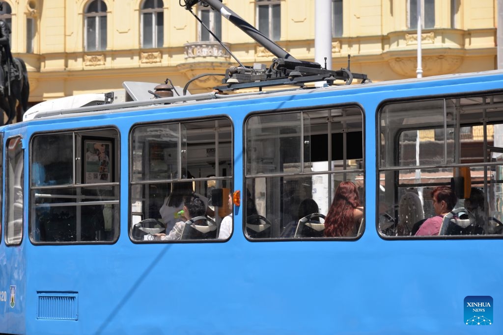 A tram with its windows open drives through a central square amid a heatwave in Zagreb, the capital of Croatia, June 25, 2026. Croatia has been experiencing a heatwave for several days, with some areas seeing temperatures exceeding 35 degrees Celsius. (Xinhua/Ma Zhen)
