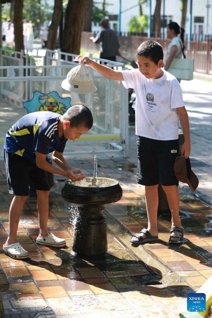 Children play near a tap in Bishkek, Kyrgyzstan, June 25, 2026. (Photo by Roman/Xinhua)