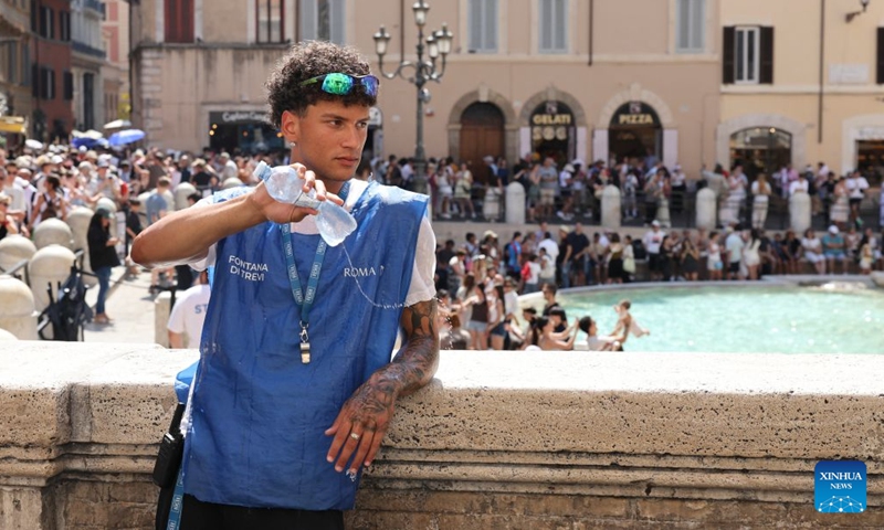 A staff member of the Trevi Fountain cools off with a bottle of water amid a heatwave in Rome, Italy, June 26, 2026. (Photo: Xinhua)
