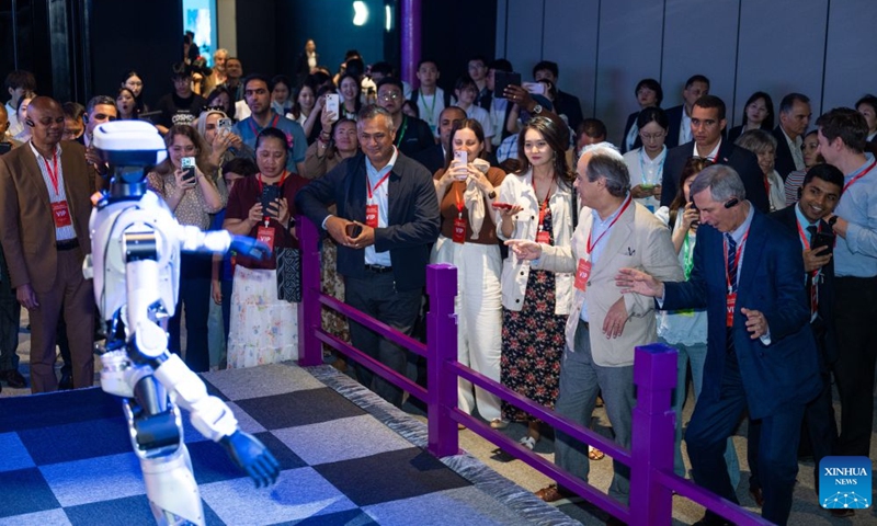 Foreign diplomatic envoys watch a humanoid robot performance in an immersive exhibition in Wuhan, central China's Hubei Province, June 24, 2026.

