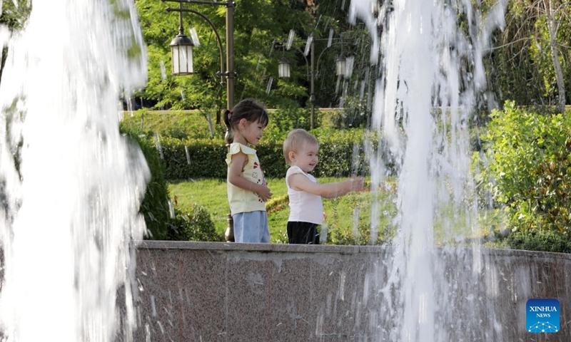 Children cool off by a fountain amid a heatwave in Tashkent, Uzbekistan, June 27, 2026. (Photo by Zafar Khalilov/Xinhua)

