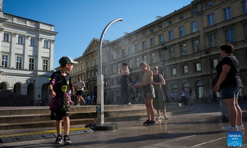 People cool off under a public misting device in Warsaw, Poland, June 27, 2026. Poland's Institute of Meteorology and Water Management has issued its highest, third-level heat warnings from Saturday morning to Monday evening.

