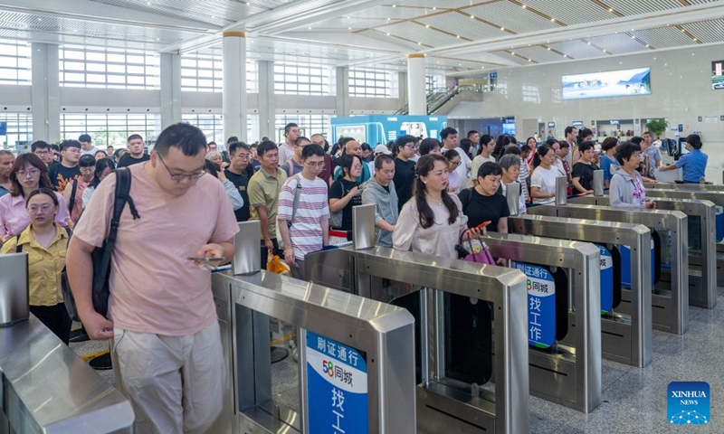 Passengers pass through ticket gates to board a train at the Shengzhou Xinchang Railway Station in Shengzhou, east China's Zhejiang Province, June 27, 2026. 