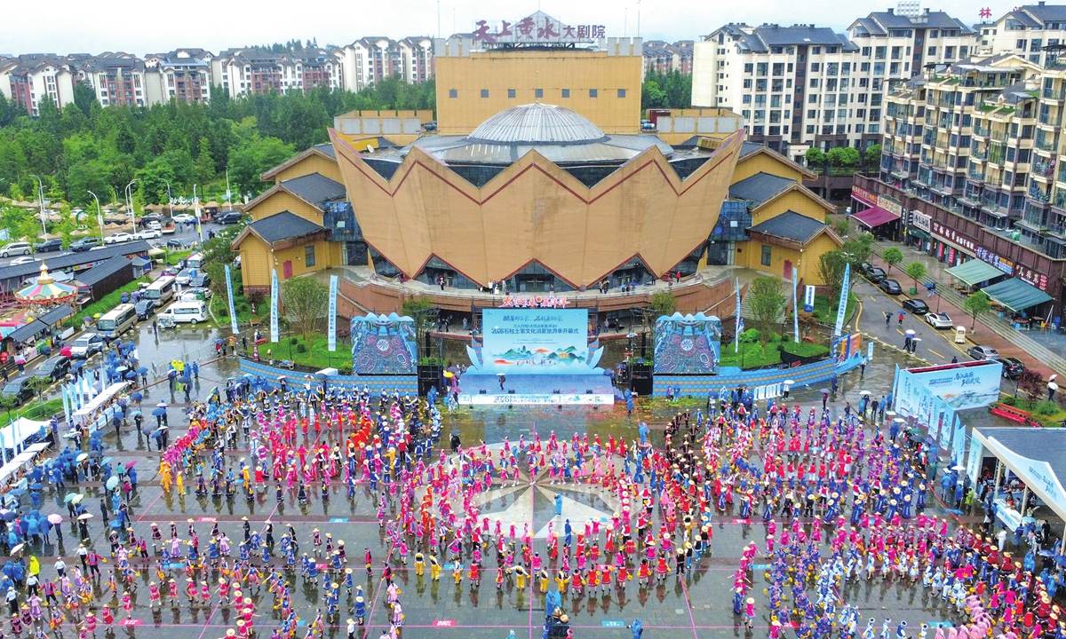 Nearly a thousand members of the Tujia ethnic group, dressed in traditional ethnic costumes, perform the Baishou Dance in front of a theater in Shizhu Tujia Autonomous County of Chongqing Municipality on June 29, 2026, showcasing their rich cultural heritage. Photo: VCG