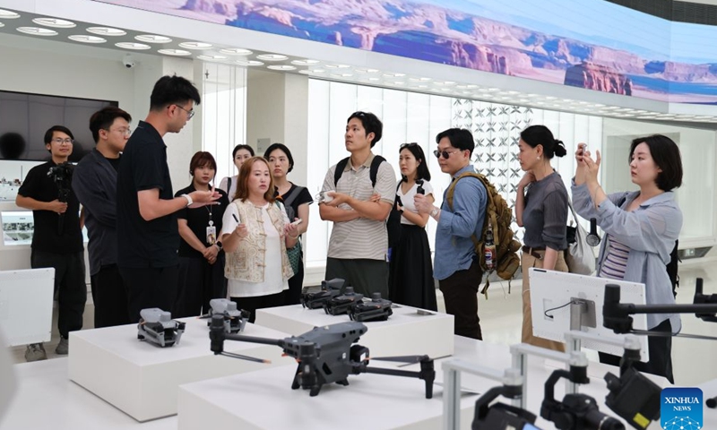 Media delegation members from the Republic of Korea (ROK) learn about products at a flagship store of drone-manufacturing giant DJI in Nanshan District of Shenzhen, south China's Guangdong Province, June 24, 2026. From Tuesday to Friday this week, a six-member ROK media delegation paid a visit to Shenzhen, China's high-tech powerhouse, to get a first-hand sense of the city's dynamic development. (Xinhua/Liang Xu)

