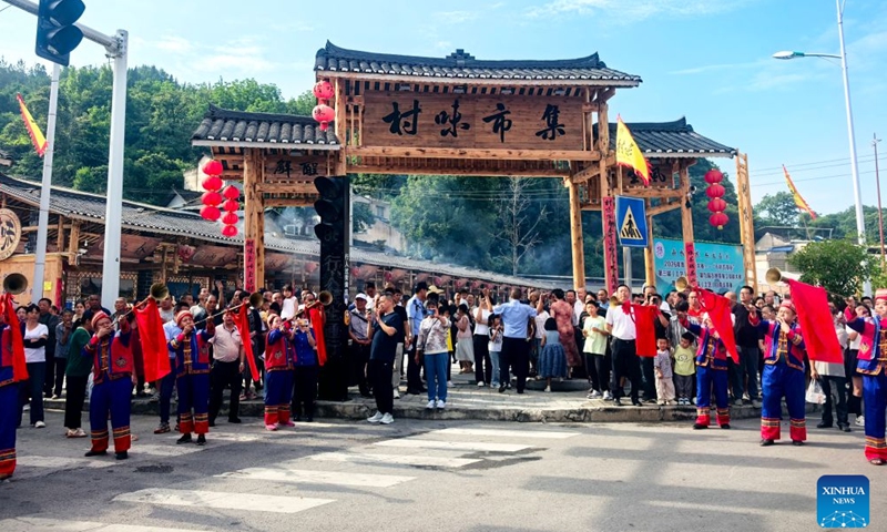 People attend an event themed on village flavors in Shiqian County, Tongren City, southwest China's Guizhou Province, June 27, 2026. A series of events themed on village flavors were held in Shiqian County over the weekend. More than 10 village- or community-based teams competed in cuisine contests using local ingredients such as Shiqian moss tea and seasonal produce. Parades featuring intangible cultural heritage, recreational competitions and other activities were also held to showcase local cuisine and rural traditions. (Photo by Sun Wei/Xinhua)

