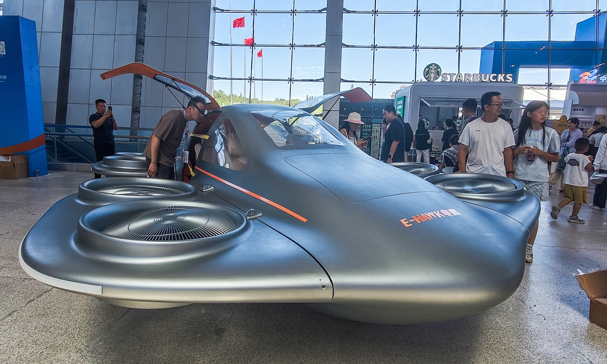 Visitors check out the EFC1200 fully ducted eVTOL - which bears a striking resemblance to a flying saucer - developed by E-Hawk Technology, at the 9th China-Eurasia Expo in Urumqi, Northwest China's Xinjiang Uygur Autonomous Region, on the final day before the expo closed on June 29, 2026. Photo: VCG