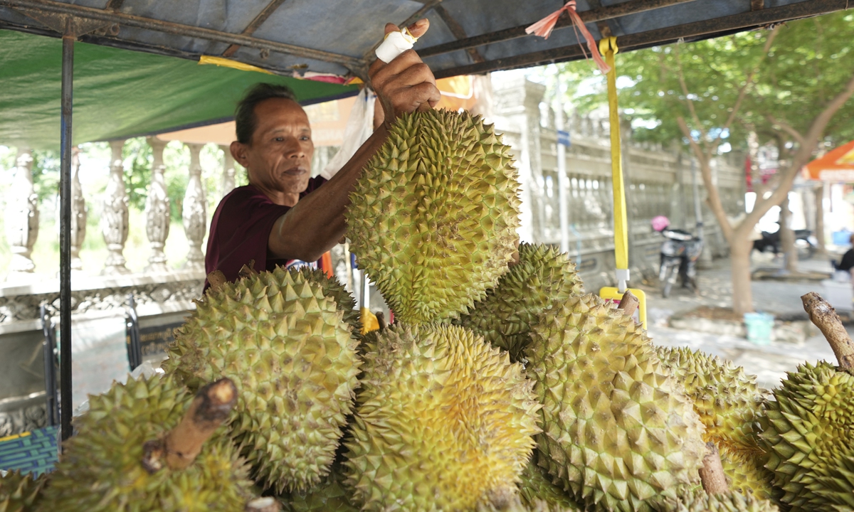 A vendor cuts a durian at his fruit's store in a village outside Phnom Penh, Cambodia. File photo: VCG