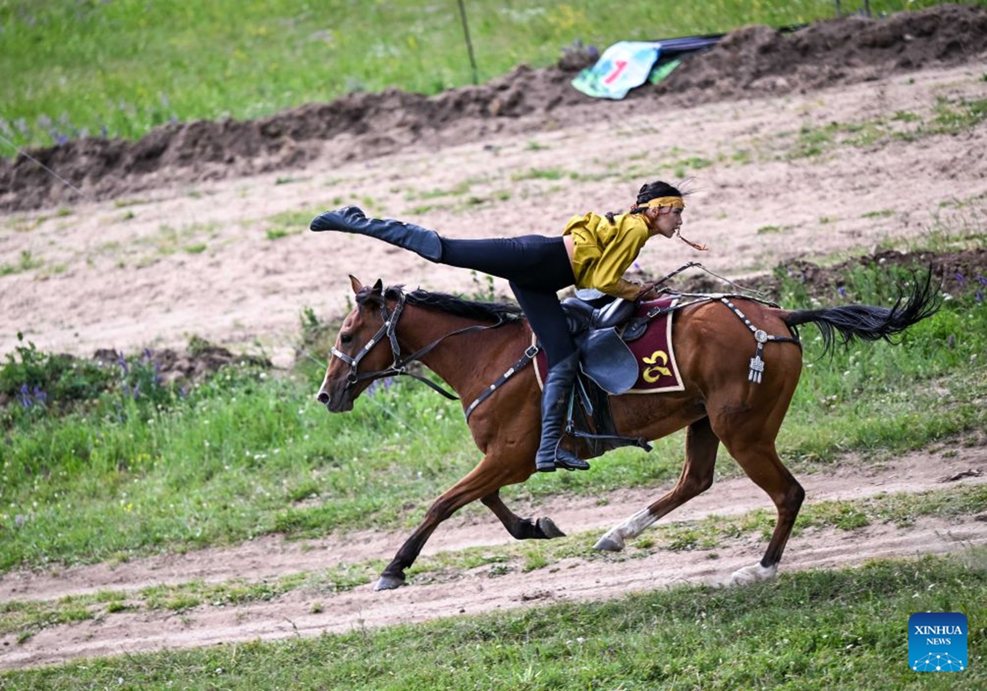 A rider performs horseback stunts during a grand ethnic cultural event in Karkara, Almaty Region, Kazakhstan, on June 27, 2026. (Xinhua/Li Renzi)

