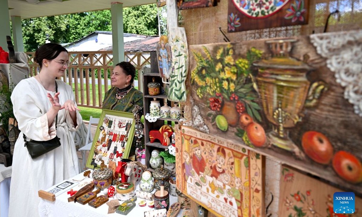 A visitor selects traditional ornaments at an art market in Ostankino Park in Moscow, Russia, on June 28, 2026. From June 27 to 28, a variety of events were held at Ostankino Park to mark the Sheremetev Festival. (Xinhua/Feng Kaihua)

