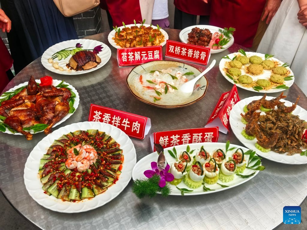 Local specialty dishes are seen at an event themed on village flavors in Shiqian County, Tongren City, southwest China's Guizhou Province, June 27, 2026. A series of events themed on village flavors were held in Shiqian County over the weekend. More than 10 village- or community-based teams competed in cuisine contests using local ingredients such as Shiqian moss tea and seasonal produce. Parades featuring intangible cultural heritage, recreational competitions and other activities were also held to showcase local cuisine and rural traditions. (Photo by Sun Wei/Xinhua)

