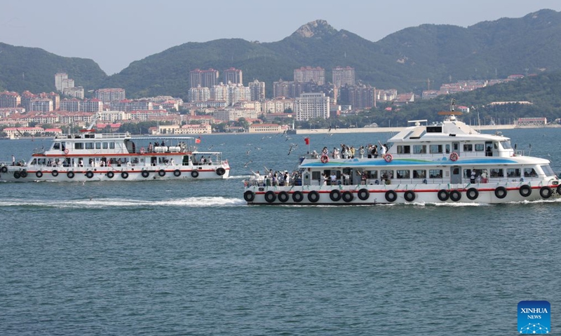 Tourists take ferries to visit the Liugong Island in Weihai City, east China's Shandong Province, June 28, 2026. (Photo by Chen Hongqing/Xinhua)

