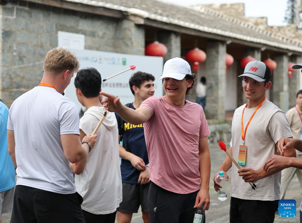 American youth take part in the Touhu game, or Pitch-pot, an ancient entertainment that requires players to throw arrows from a set distance into a tube, in front of the Kuliang Club, a historical public service community, in Kuliang, Fuzhou, southeast China's Fujian Province, June 29, 2026. The Bond with Kuliang: 2026 China-U.S. Youth Baseball Exhibition Games and Sports Festival, themed on Pitch across Oceans, Catch the Future, kicked off in Fuzhou on Monday. (Photo: Xinhua)