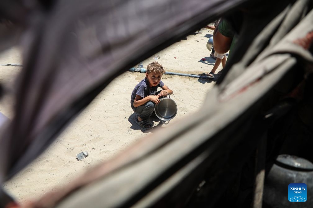 A Palestinian boy waits to receive free food from a community kitchen, in Jabalia refugee camp, northern Gaza Strip, June 29, 2026. (Photo: Xinhua)