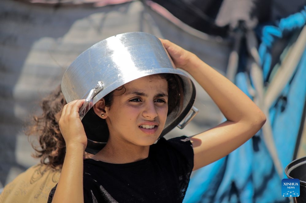 A Palestinian child waits to receive free food from a community kitchen, in Jabalia refugee camp, northern Gaza Strip, June 29, 2026. (Photo: Xinhua)