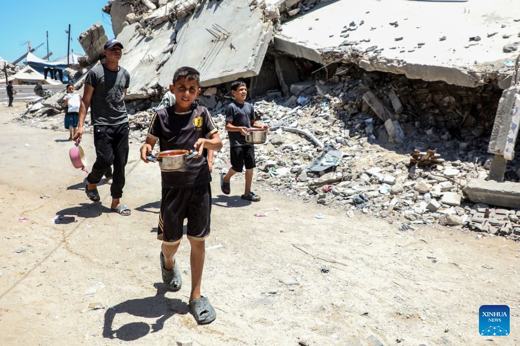 Palestinians go home after receiving free food from a community kitchen, in Jabalia refugee camp, northern Gaza Strip, June 29, 2026. (Photo: Xinhua)