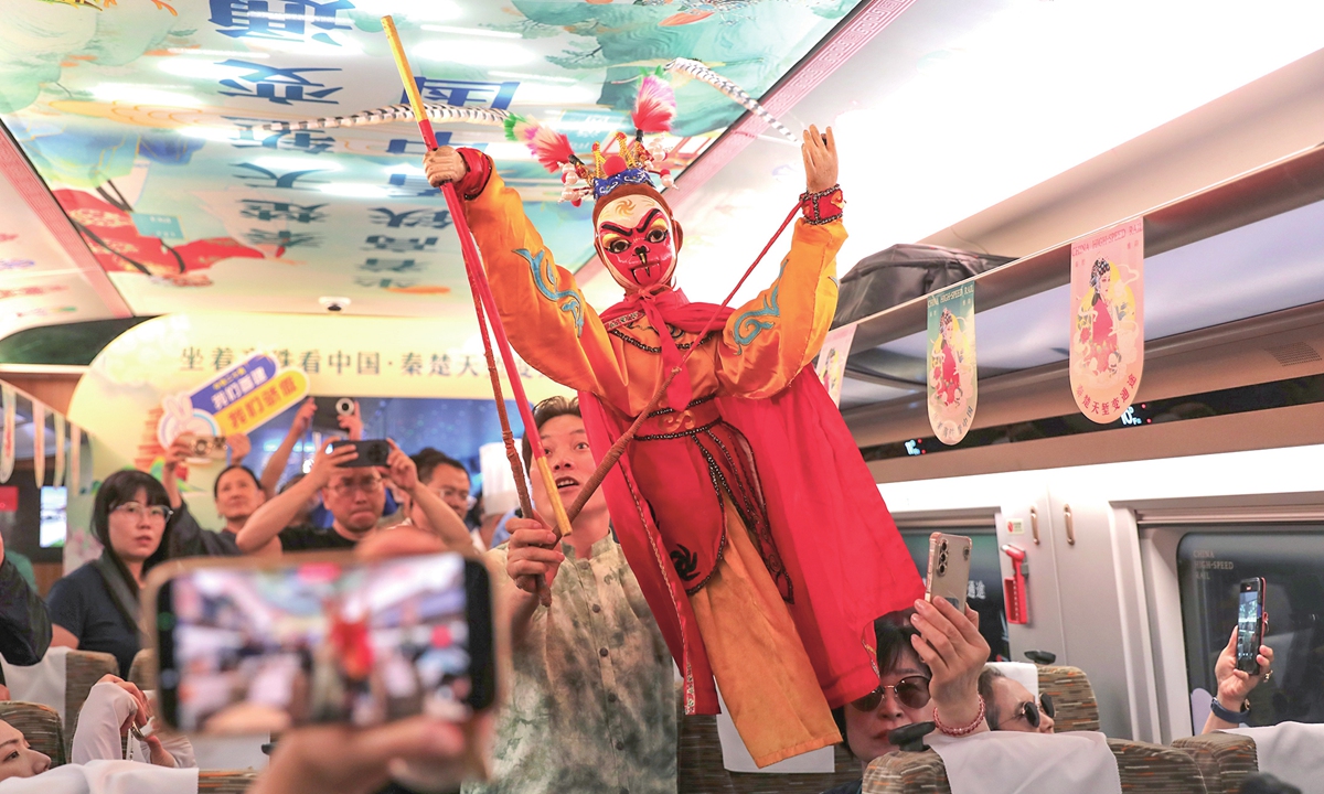 Railway staff perform a puppet show aboard high-speed train G3966 which departed from Xi'an, Northwest China's Shaanxi Province on June 30, 2026. The high-speed railway connecting Xi'an and Shiyan in Central China's Hubei Province, which traverses the Qinling Mountains, officially began operations on Tuesday, reducing the fastest travel time between Xi'an and Wuhan, the capital of Hubei, to 2 hours and 14 minutes. Photo: IC