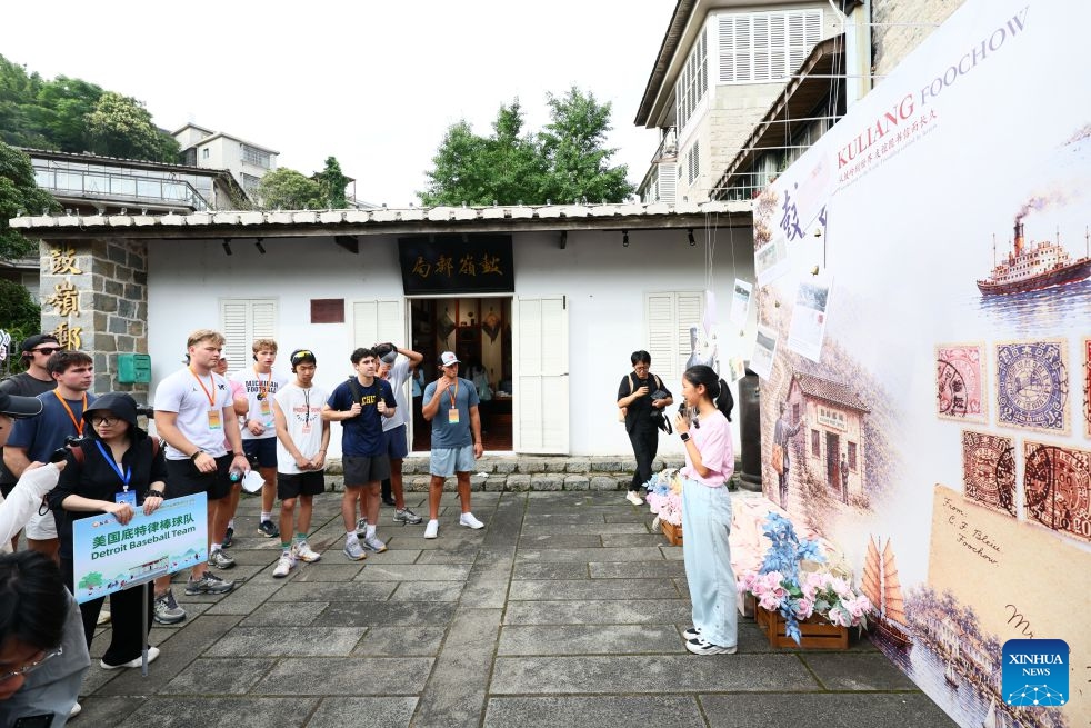 A local junior docent gives explanations in English to American youth visiting the Kuliang Post Office in Kuliang, Fuzhou, southeast China's Fujian Province, June 29, 2026. The Bond with Kuliang: 2026 China-U.S. Youth Baseball Exhibition Games and Sports Festival, themed on Pitch across Oceans, Catch the Future, kicked off in Fuzhou on Monday. Chinese and American youth attending the festival visited Kuliang on the same day to explore its cultural imprints and learn about the touching past of friendly exchanges between the people of China and the United States. (Photo: Xinhua)