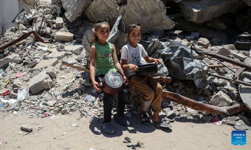 Palestinian girls wait to receive free food from a community kitchen, in Jabalia refugee camp, northern Gaza Strip, June 29, 2026. (Photo: Xinhua)