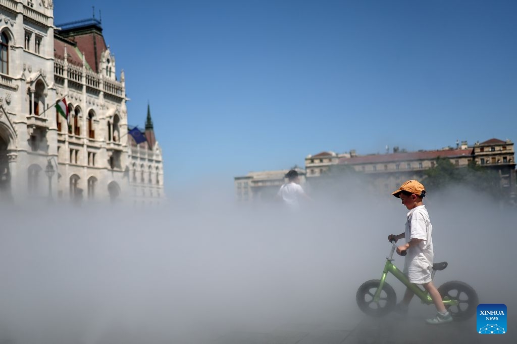 A boy cools off with a mist cooling system amid a heatwave in Budapest, Hungary, June 29, 2026. Hungary remains under a third-degree heat alert, the country's highest level, with temperatures forecast to reach between 35 and 40 degrees Celsius across much of the country in the coming days. (Photo: Xinhua)