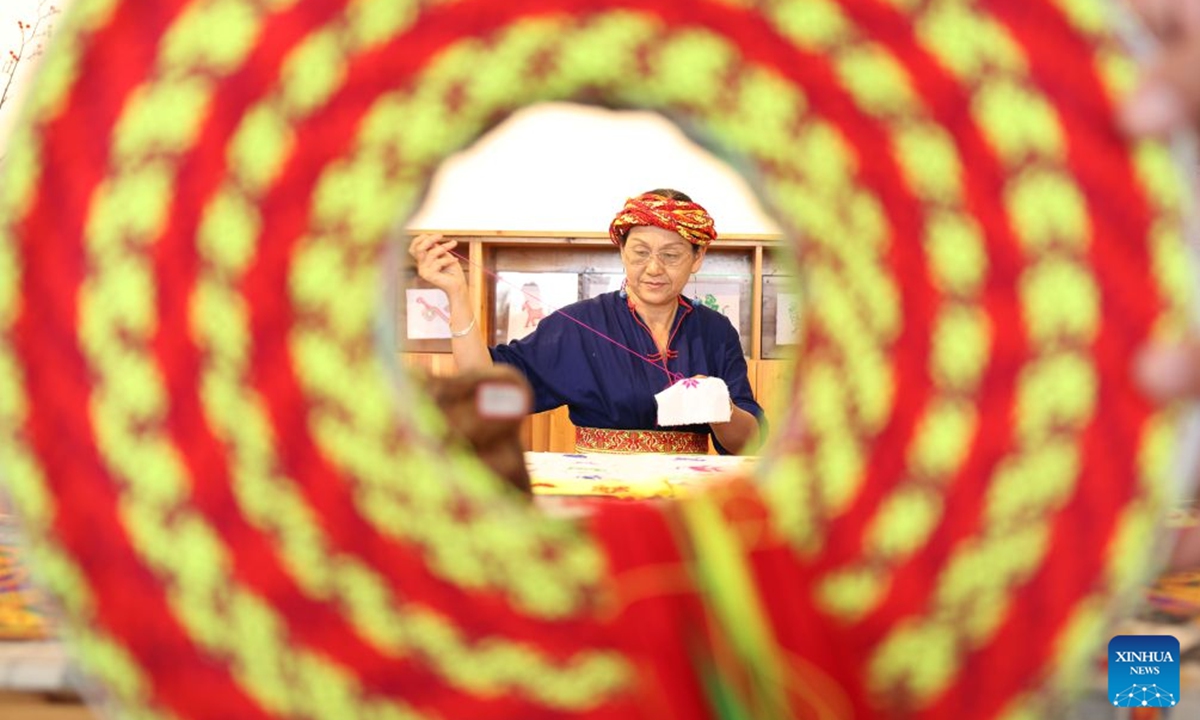 A woman from Huayao branch of Yao ethnic group makes Tiaohua cross-stitch embroidery in Longhui County of Shaoyang, central China's Hunan Province, June 23, 2026. Tiaohua cross-stitch embroidery is a traditional handicraft passed down through generations by women of Huayao, a branch of Yao ethnic group, in Longhui County. (Xinhua/Zhao Zhongzhi)