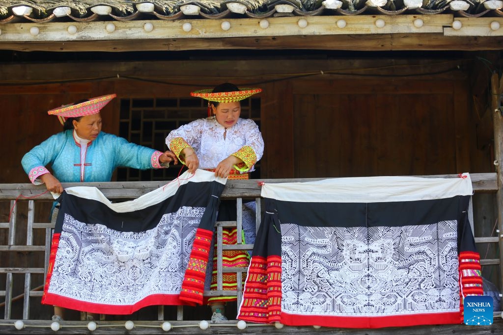 Women from Huayao branch of Yao ethnic group display traditional tube skirts made with Tiaohua cross-stitch embroidery in Longhui County of Shaoyang, central China's Hunan Province, Aug. 6, 2022. Tiaohua cross-stitch embroidery is a traditional handicraft passed down through generations by women of Huayao, a branch of Yao ethnic group, in Longhui County.(Photo by Zeng Yong/Xinhua)