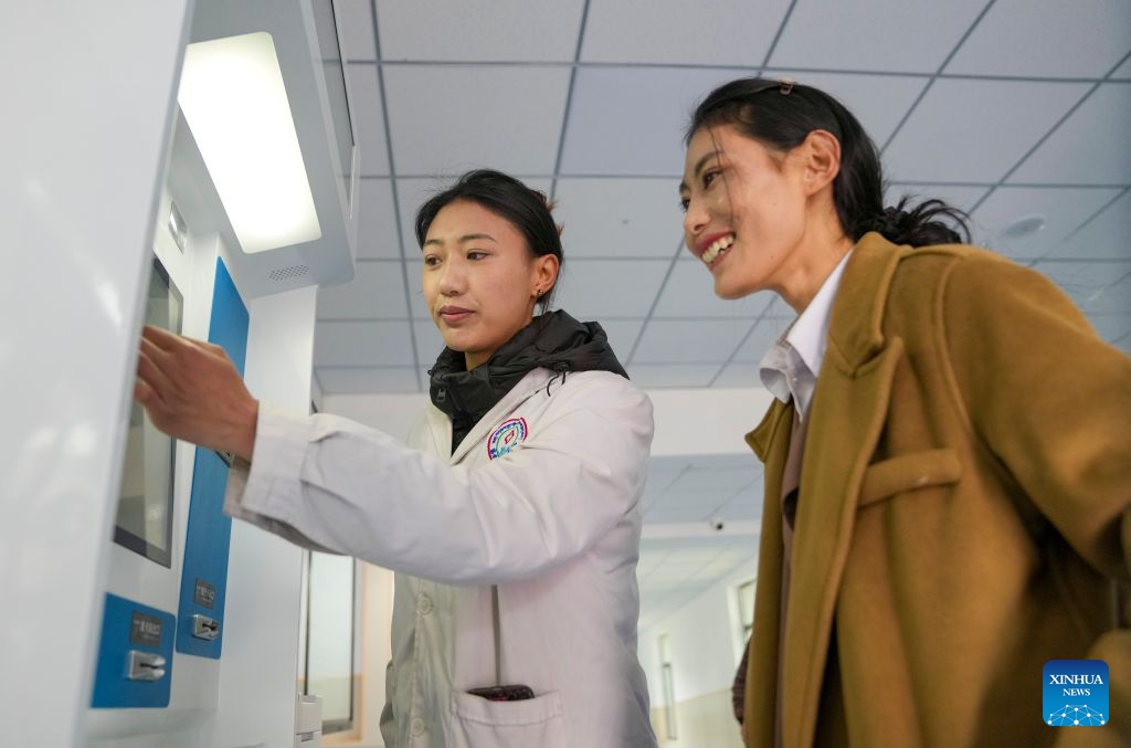 Nyima Lhamo (L) guides a patient at a local hospital in Damxung County of Lhasa, southwest China's Xizang Autonomous Region, May 28, 2026. (Xinhua/Jigme Dorje)